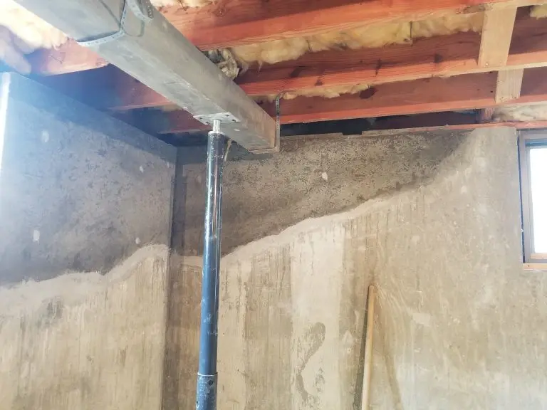 Basement foundation wall showing structural settling before repair, illustrating a Foundation Piering Cost Guide comparison for push piers and helical piers.