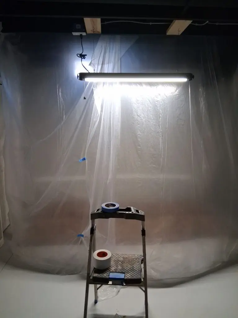 Basement interior protected with plastic containment barriers during a professional egress window installation project in Perrysburg, OH.