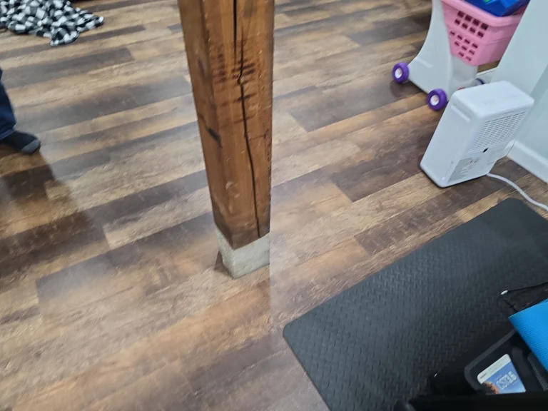 Cracked wooden basement support beam in Swanton OH showing structural damage before repair