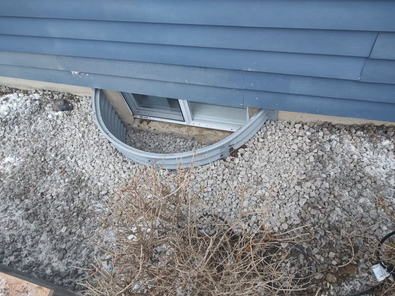 Window well with gravel drainage system installed next to basement window in Waterville Ohio