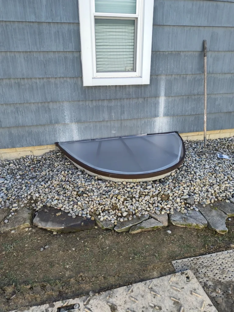 Completed basement egress window installation in Perrysburg, OH with a covered composite window well