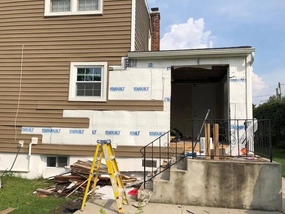 Exterior home renovation project with insulation and waterproofing preparation before basement finishing