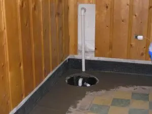 Sump pump pit installation in a basement floor to prevent water accumulation and flooding
