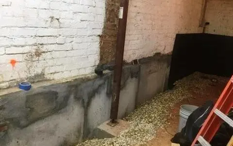 Foundation waterproofing inspection showing moisture staining along a basement foundation wall