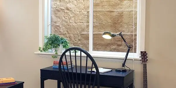 Energy-efficient basement window above a home office desk improving insulation and natural light