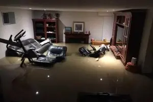 Flooded finished basement caused by severe water intrusion before waterproofing repairs in Connecticut