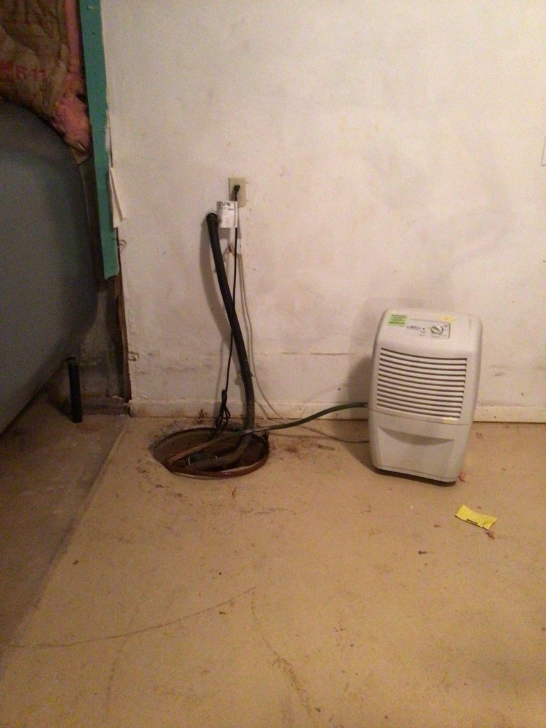 Old sump pump pit in basement before waterproofing upgrade in Marlborough CT
