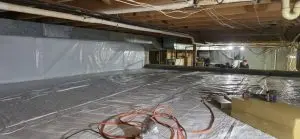 Crawlspace encapsulation with vapor barrier installed to improve indoor air quality and moisture control