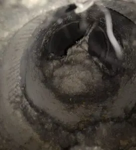 Dirty air duct interior showing accumulated dust and debris, highlighting potential fire hazards and health risks associated with neglected air ducts.