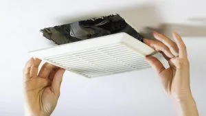 Hands removing a dirty air duct cover, revealing dust and debris, highlighting the importance of regular air duct cleaning for improved indoor air quality and HVAC efficiency.