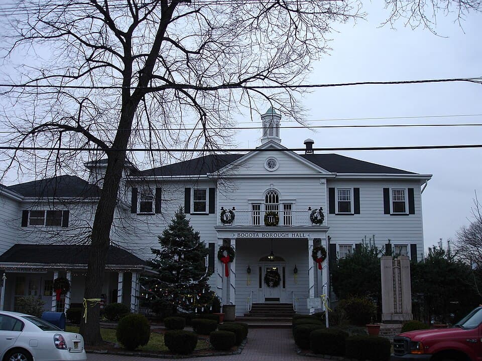 Bogota Borough Hall building with seasonal decorations, located in Bogota, NJ, surrounded by trees and landscaping, relevant to basement waterproofing and mold remediation services.