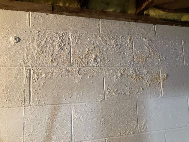 Basement wall showing signs of damage with cracks and discoloration, indicating potential foundation issues in New Jersey homes.