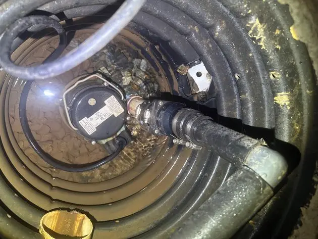 Sump pump and discharge pipe in basement sump pit, preventing basement flood.