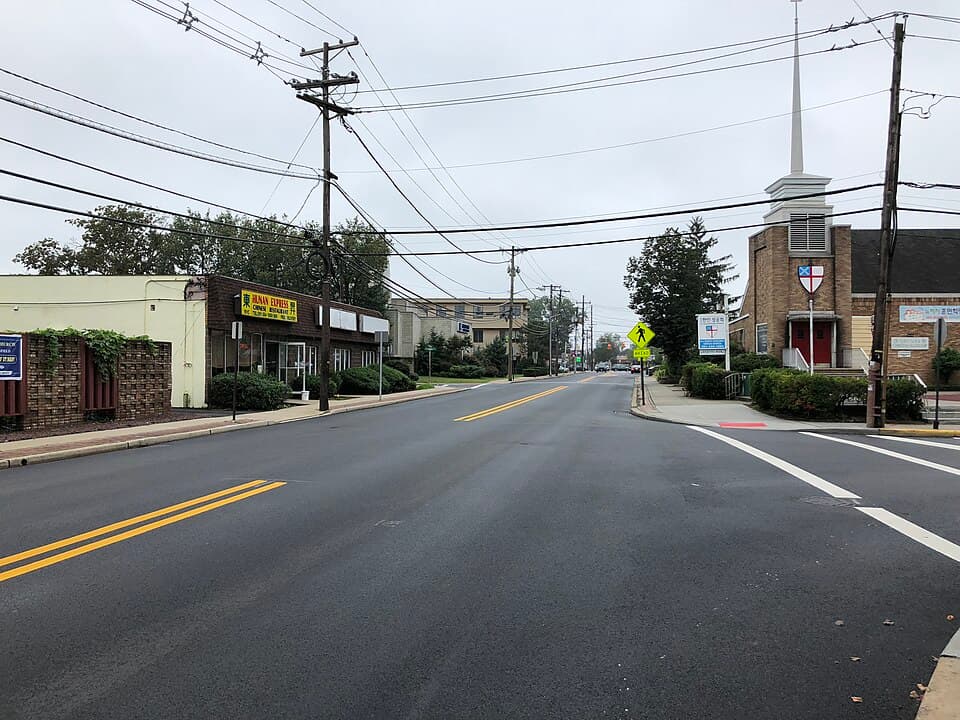 Bergenfield, NJ street scene with commercial buildings and church, protecting Bergenfield homes from basement leaks.