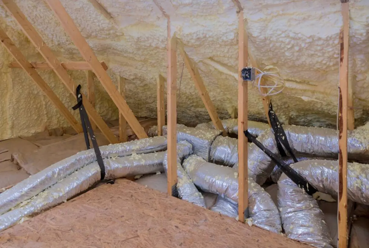 Crawl space with spray foam insulation and ductwork, protecting homes from moisture.