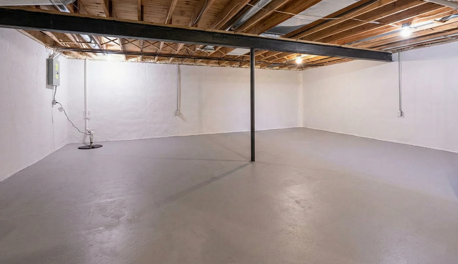 Dry, clean basement interior with concrete flooring and exposed wooden beams, showcasing a waterproofing solution by Healthy Way Waterproofing & Mold Remediation.