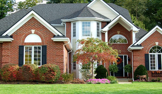 Beautiful brick house with well-maintained landscaping, showcasing a strong foundation and inviting exterior, relevant to foundation repair services.