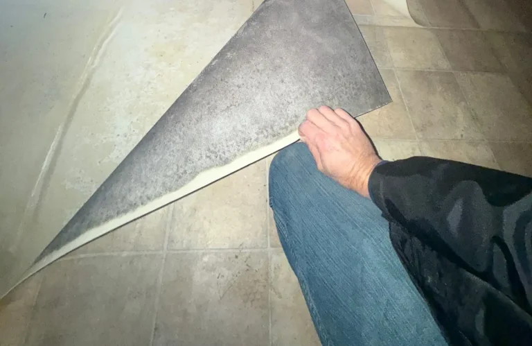 Person removing impacted flooring during mold remediation process in Princeton, NJ home.