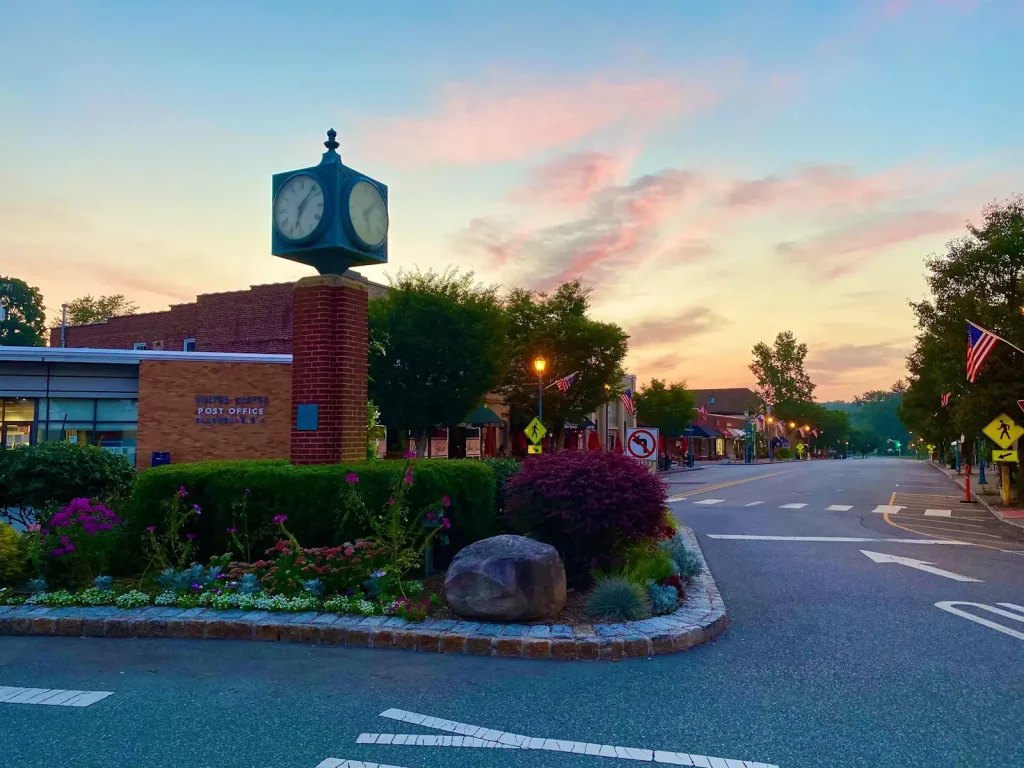 Allendale, NJ post office and town square with sunset sky and American flags.