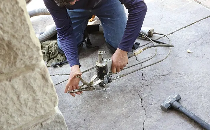 Concrete leveling expert working to repair concrete surface