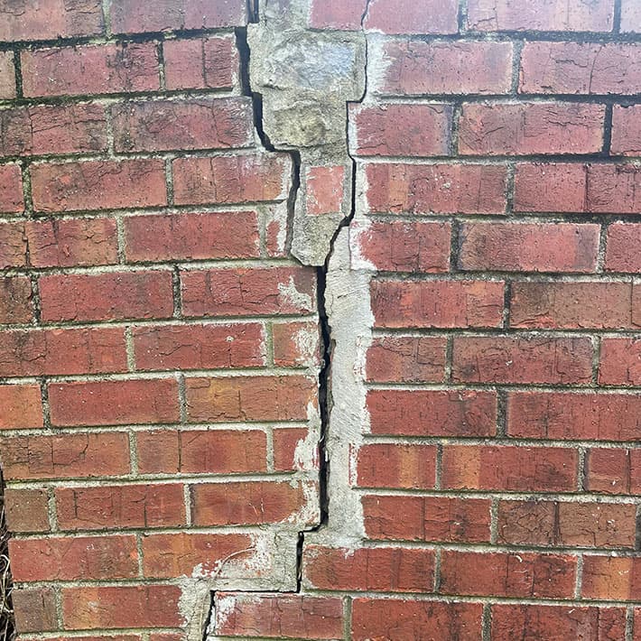 Large crack in brick foundation wall, foundation repair issues in Russellville, KY.