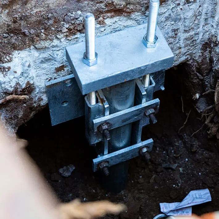 Push piers and slab piers installed beneath foundation supporting building weight.