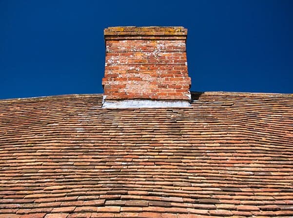 Uneven roof line and sagging exterior, potential foundation settlement signs.