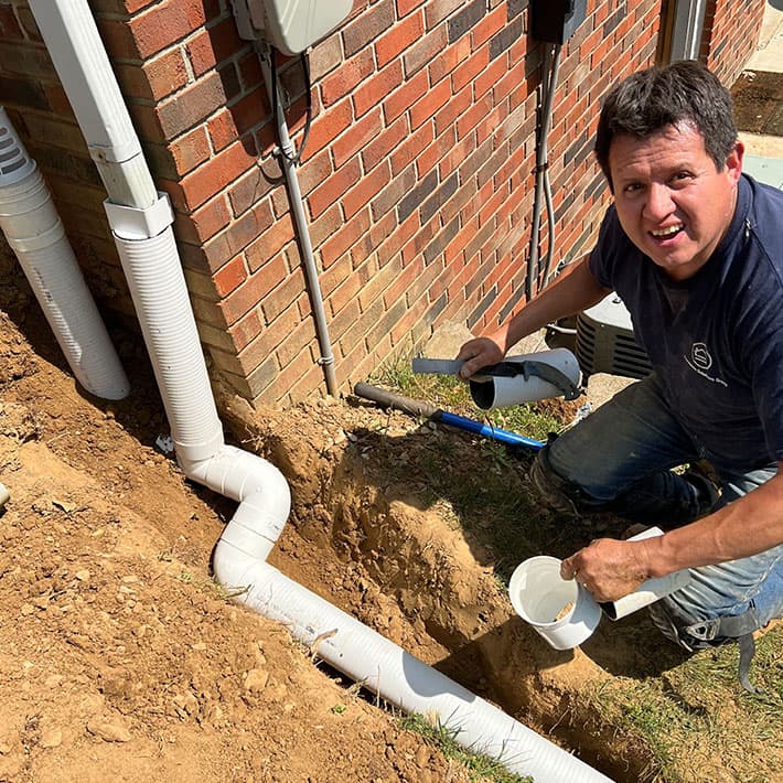 Drainage improvement around home foundation and chimney, Foundation Solutions Group expert inspecting water management.
