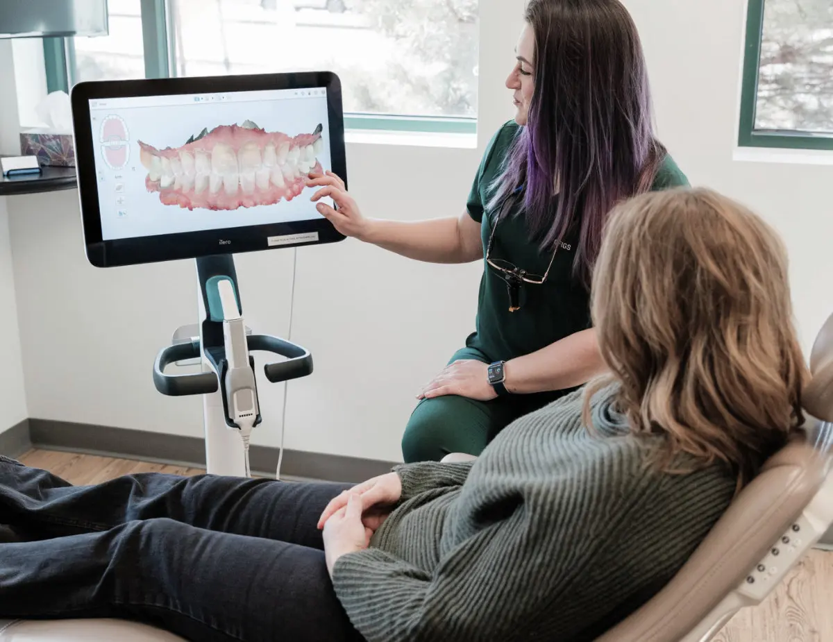 Dentist reviewing digital dental images with a patient seated in a treatment chair