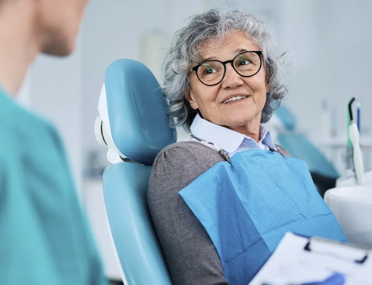 Senior patient seated in a treatment chair during a dental implant consultation