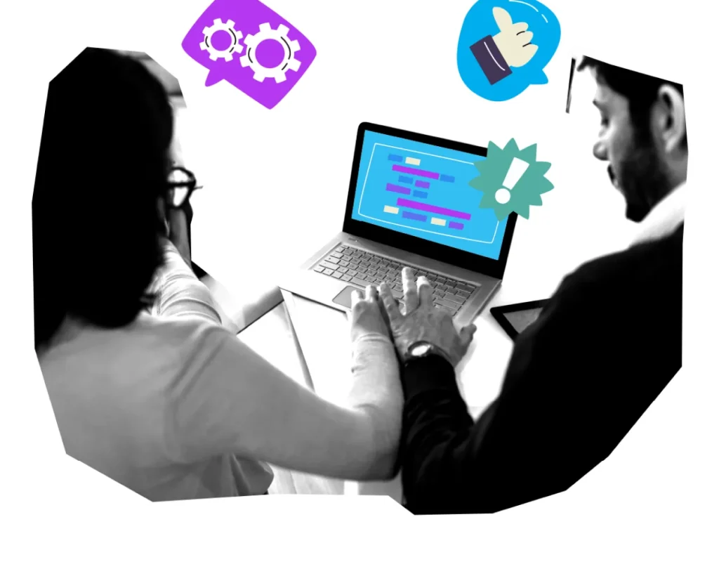Two colleagues reviewing code on laptop