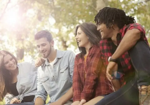 A group of people sitting on top of a bench.