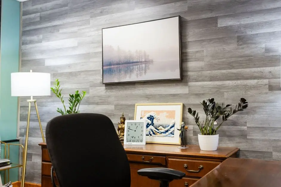 A desk with a chair and picture on the wall