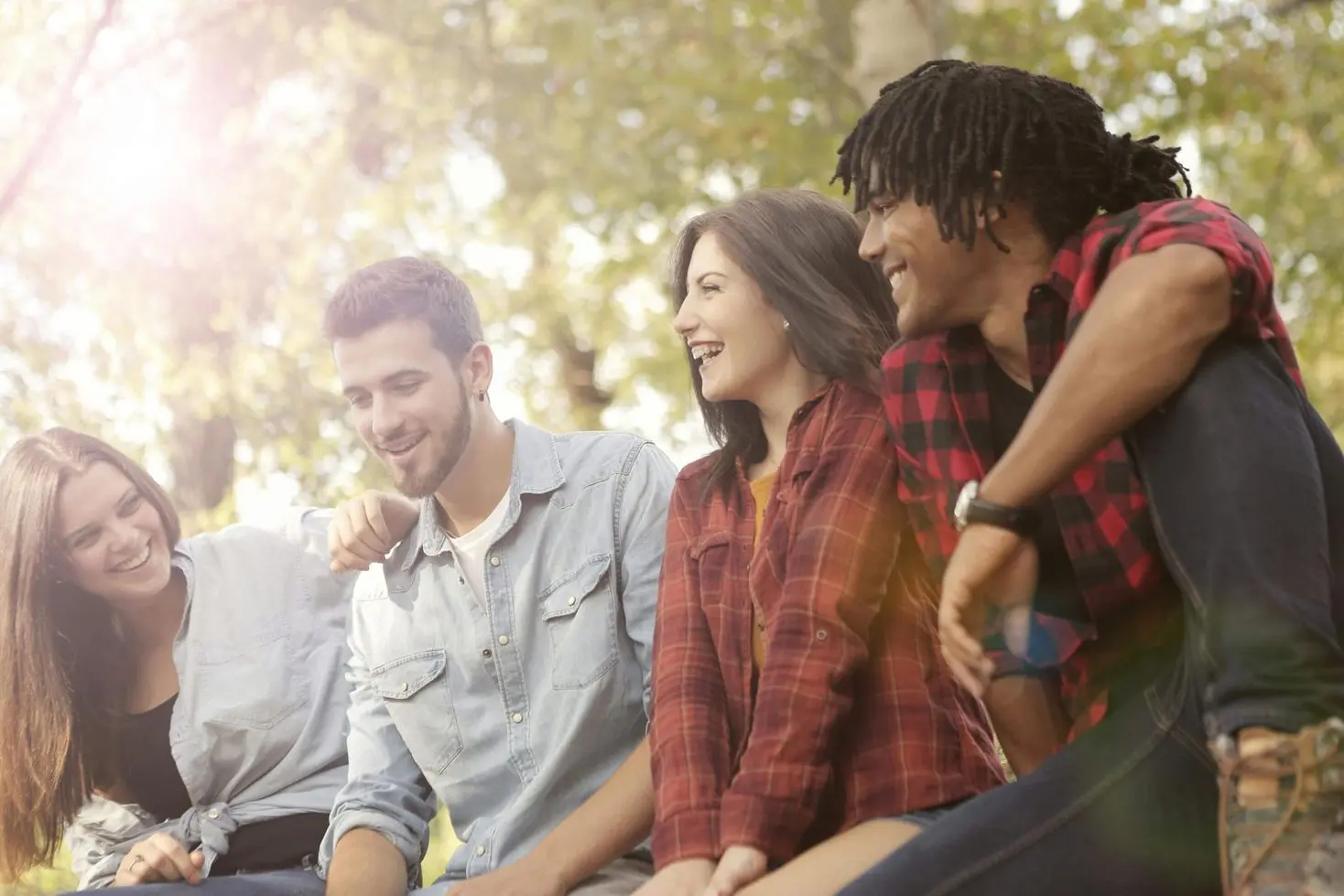A group of people sitting on top of a bench.