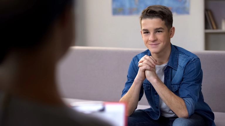 A teenage boy smiles as he connects with his therapist at Armstrong Family Counseling