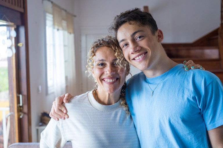 A mom and son smile and hug after family counseling