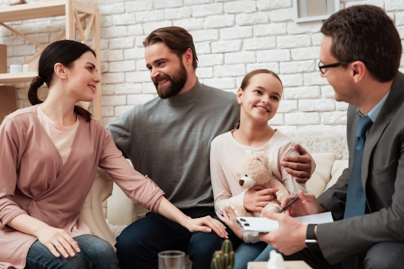 A family smiles as they participate together in a counseling session