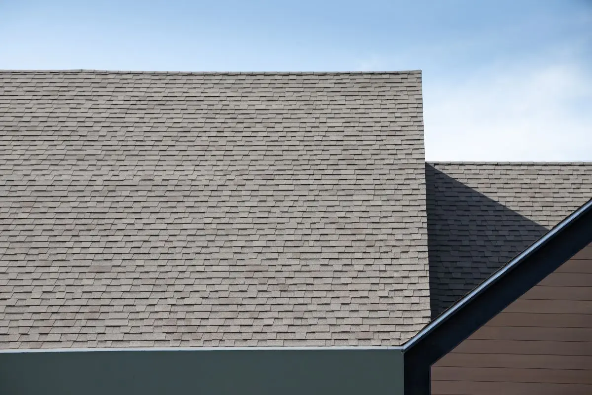 Roof shingles on top of the house against blue sky. dark asphalt tiles on the roof background, Wayzata