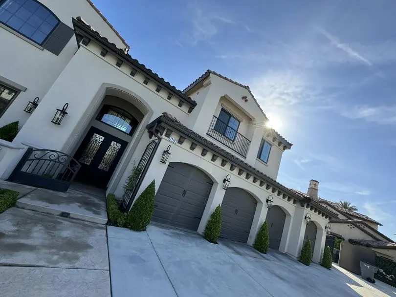 Modern two-story home in Fresno, CA with a freshly pressure-washed driveway and walkway, captured on a sunny day