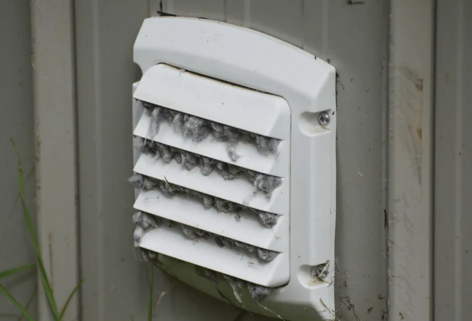 Dryer vent clogged with lint on exterior wall