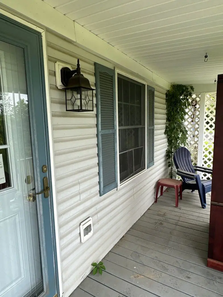 cleaning of a porch area with vinyl siding and a wooden deck using pressure washing techniques