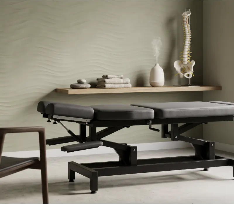 Chiropractic treatment table and spinal model in a modern Calhoun, GA clinic setting, illustrating quality