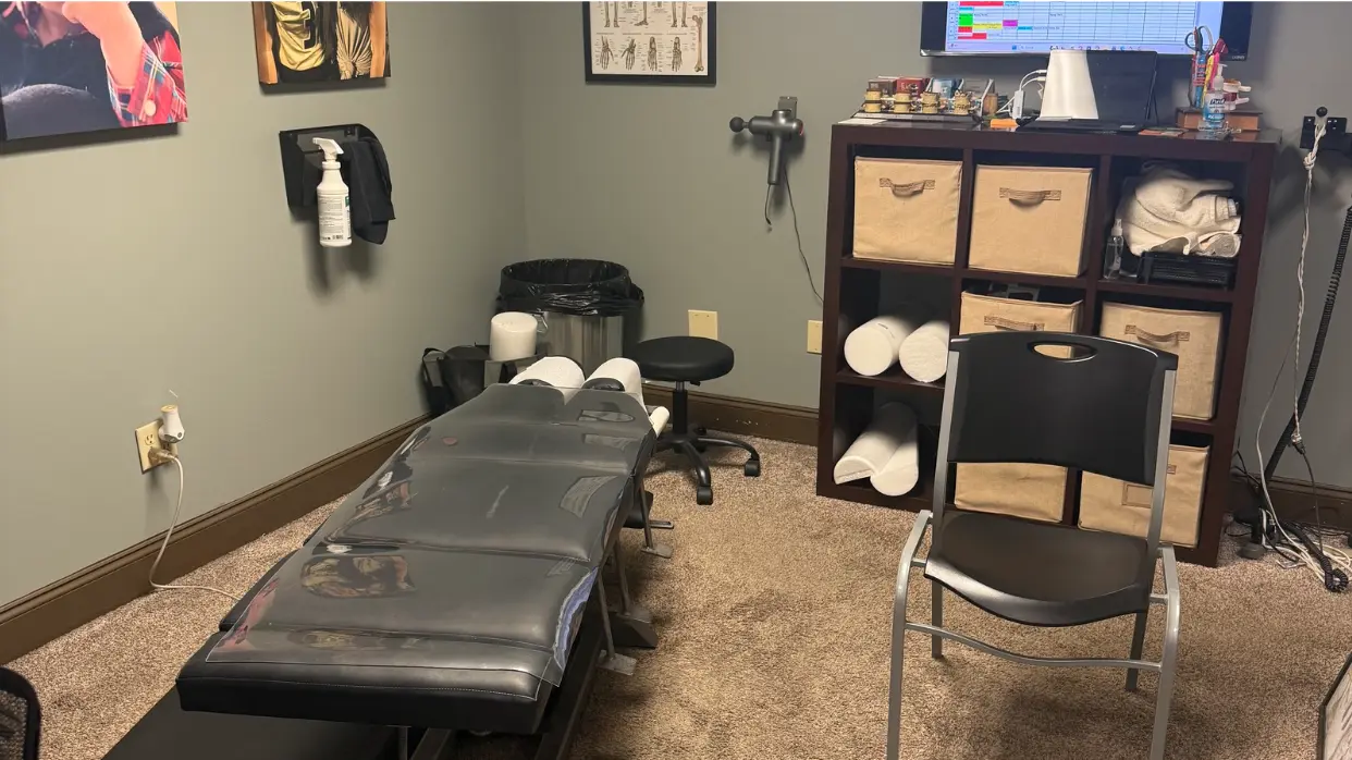 Chiropractic treatment room with adjustment table and equipment for musculoskeletal pain relief.