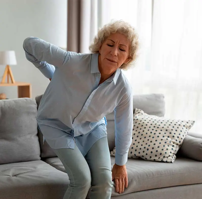 Woman experiencing back pain and discomfort, illustrating chiropractic treatment options.