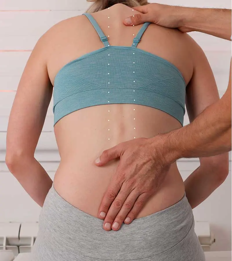 Chiropractor performing spinal manipulation and treatment on patient's back.