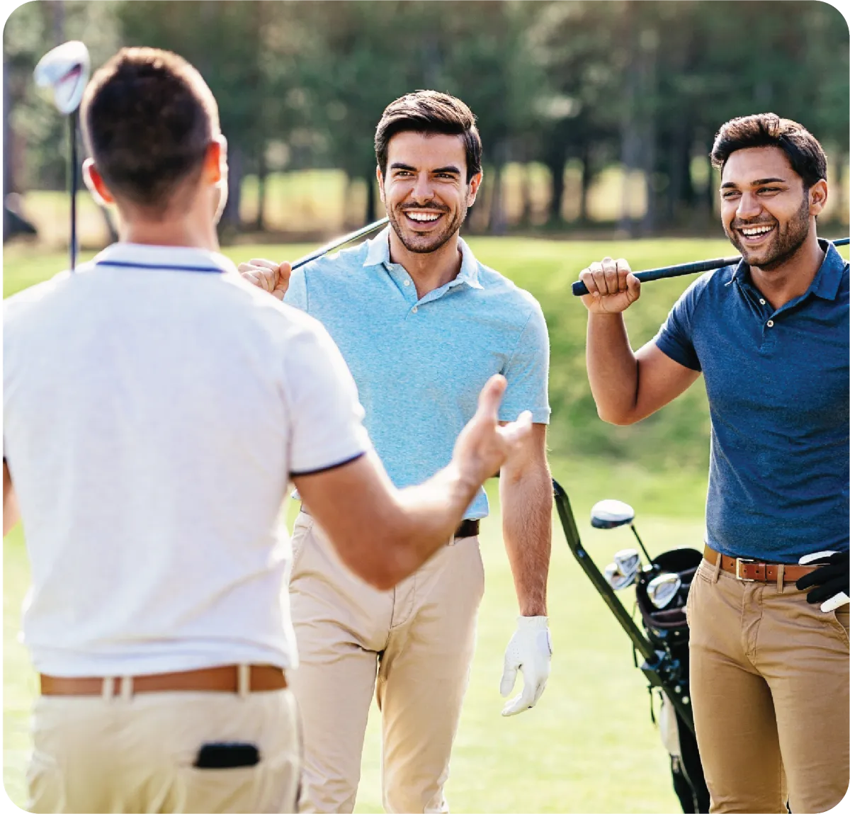 Three men smiling and playing golf together on a sunny day.