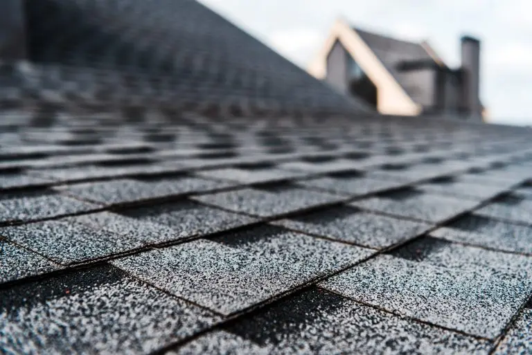factors influencing roof lifespan selective focus of grey shingles on rooftop of building