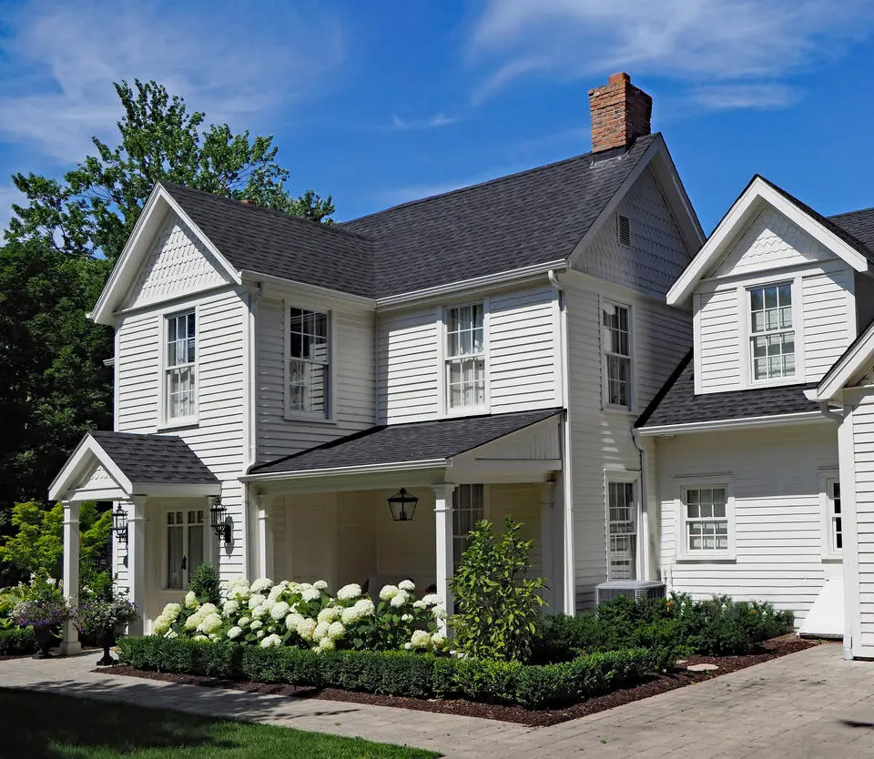 best siding for house-white vinyl siding on house with flowers planted out front