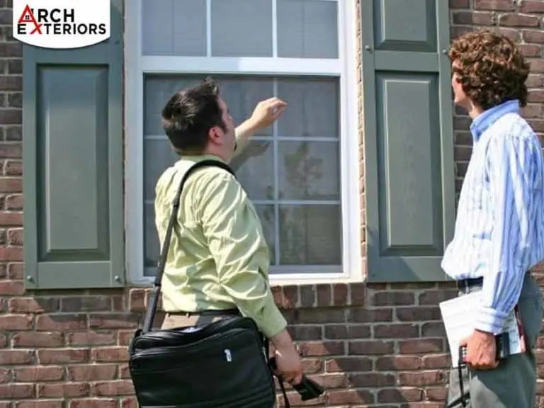 two men standing outside looking at home window estimating cost of full window replacement in Bethesda, MD