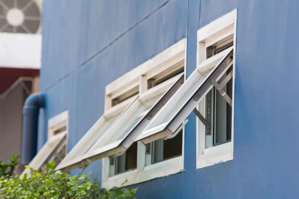 close up view of blue house in maryland with many awning windows installed